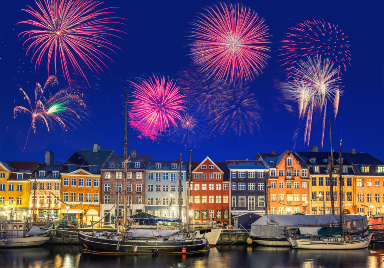 Häuser an der Wasserfront des Nyhavn mit Feuerwerk zu Silvester in Kopenhagen